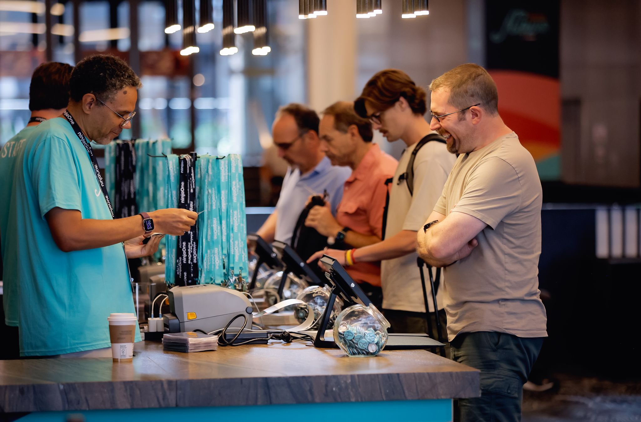 Attendees checking in and grabbing swag at an event registration counter.